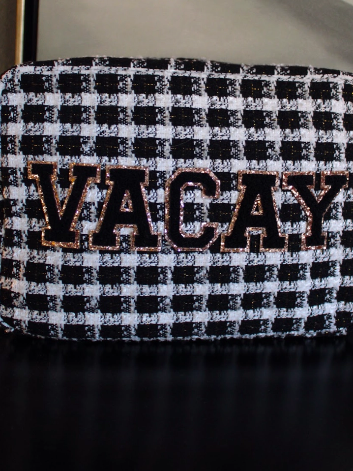 Picture of black and white tweed plaid make-up bag with varsity letter patches spelling out VACAY in black with gold trim