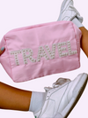 Picture of girl holding a pink nylon zipper bag with sewn on pearl embellished letter patches